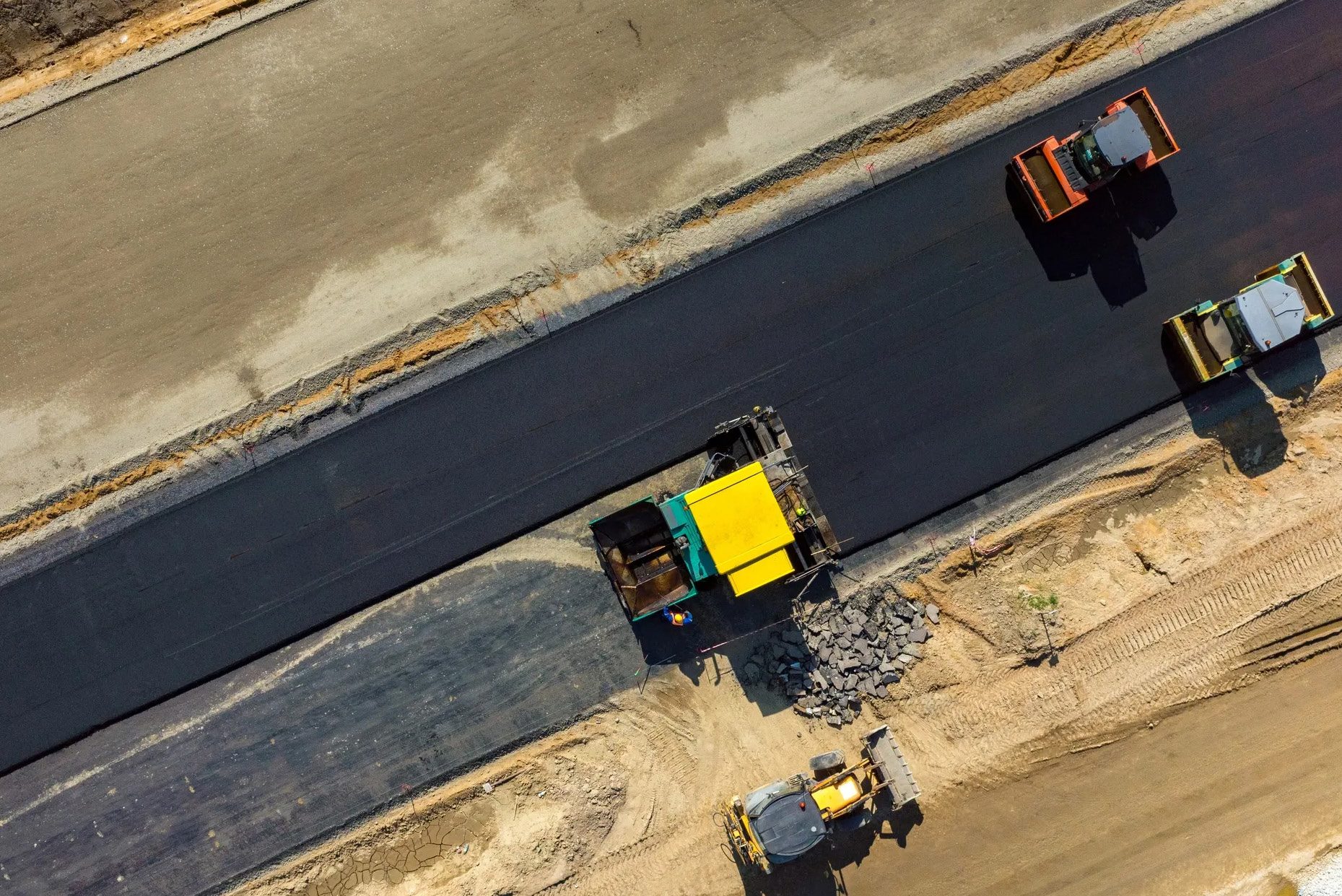 Aerial view of pavers laying fresh asphalt on a new South African highway
